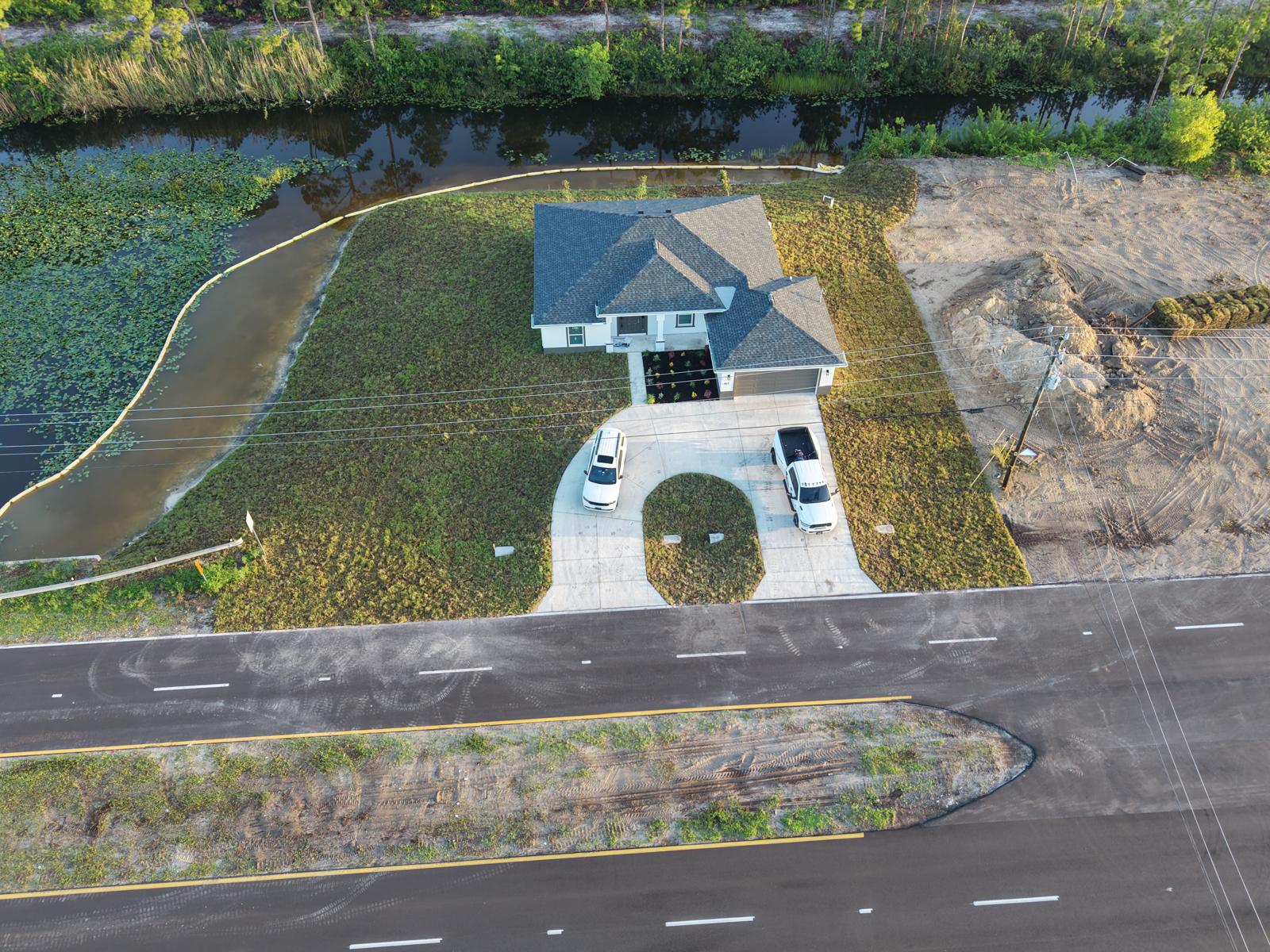 Moura General Construction — aerial view of new home on canal